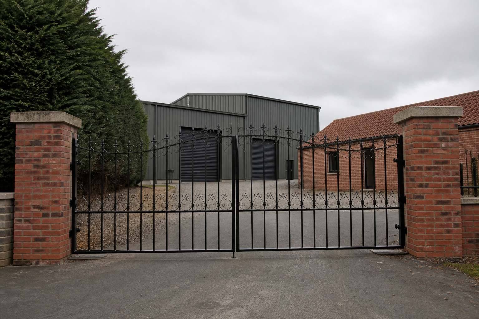 The gated entrance to Waterline Industrial Estate, Acaster Malbis: grey steel units, brick pillars and ornate metal gates, with no shop fascia