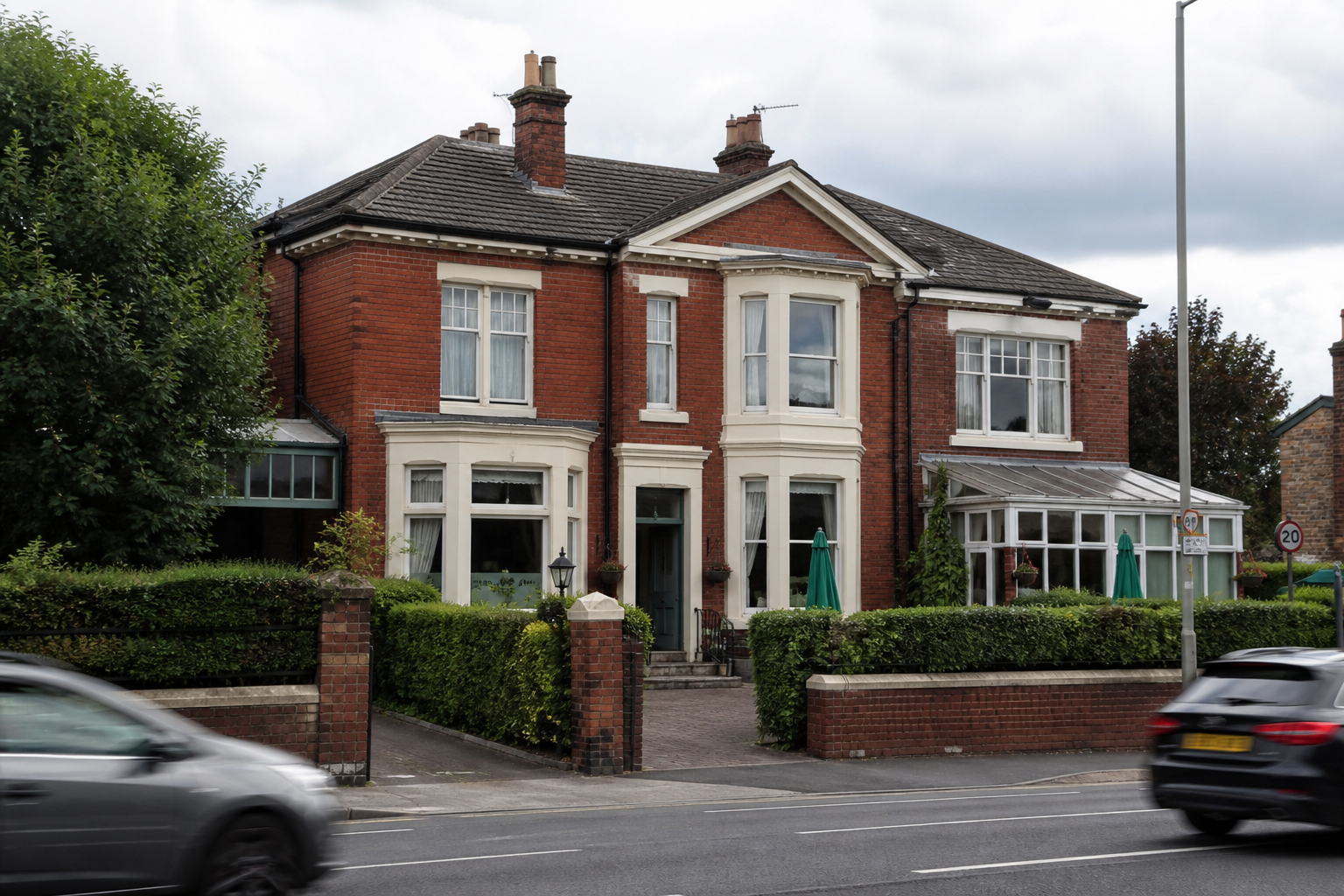 A Victorian brick guest house on an English arterial road, with no readable signs