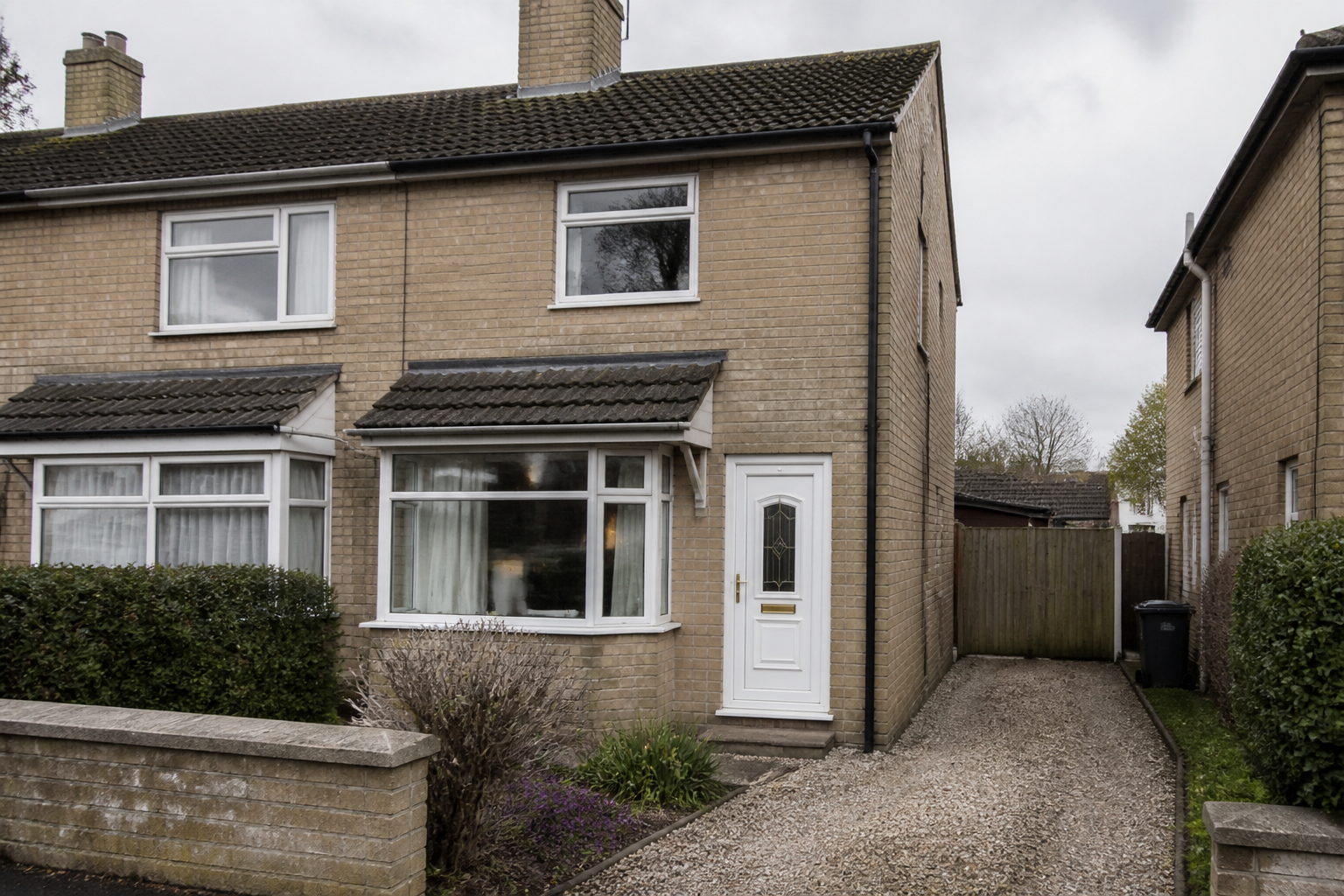 A buff-brick York house with a front garden and a gravel drive, and no shop fascia