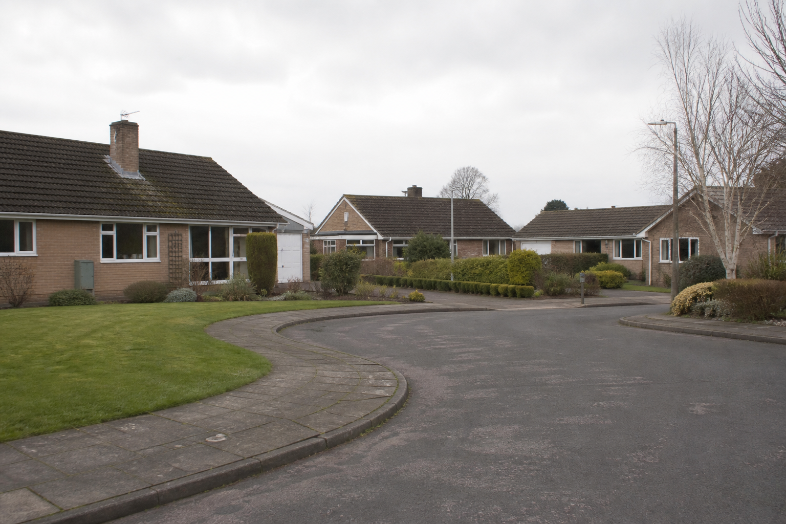 A quiet English village cul-de-sac of brick bungalows, with no house numbers and no readable signs