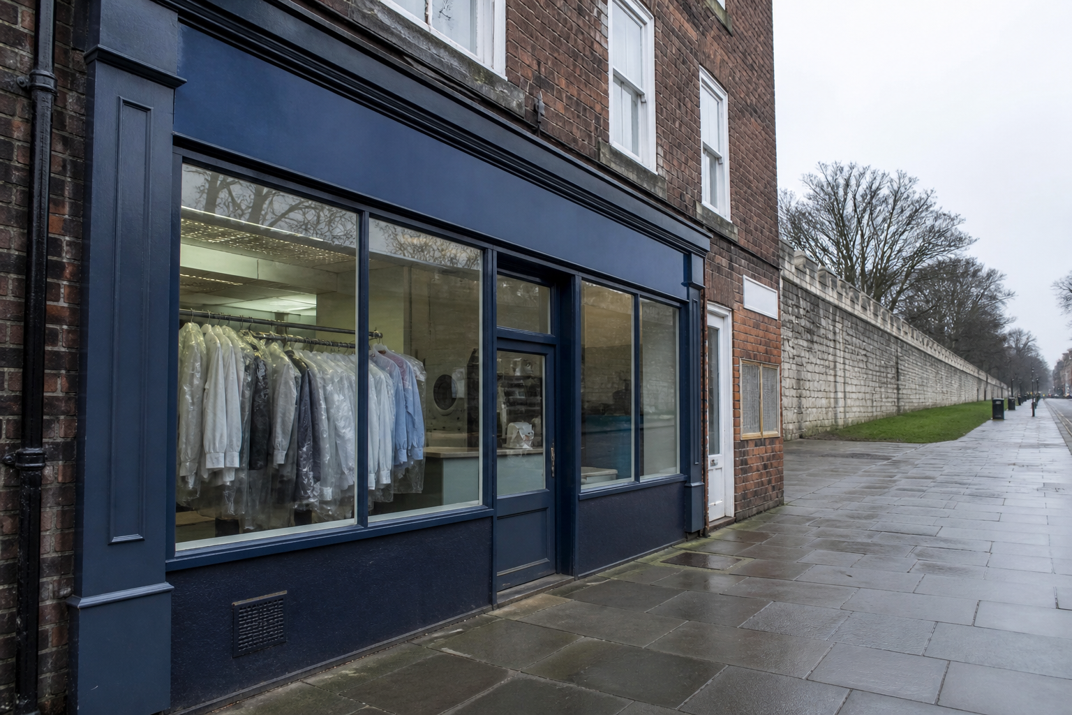 A small independent English laundry shopfront on a brick terrace street, with no readable signs