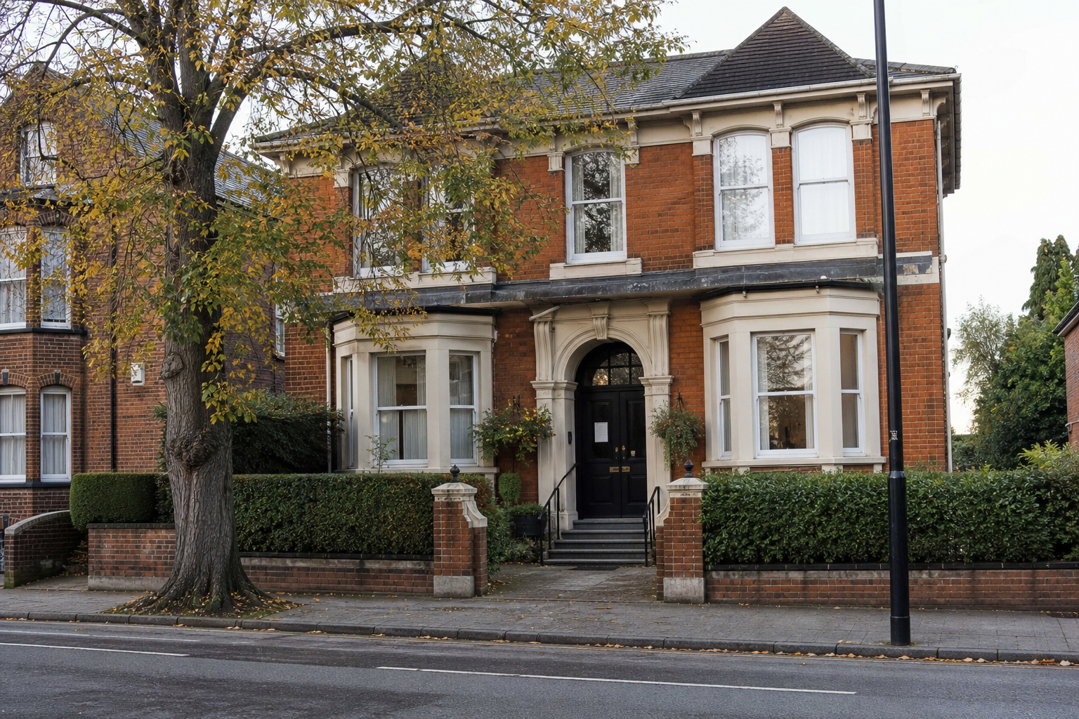 A discreet Victorian brick funeral house on an English city street, with no readable signs