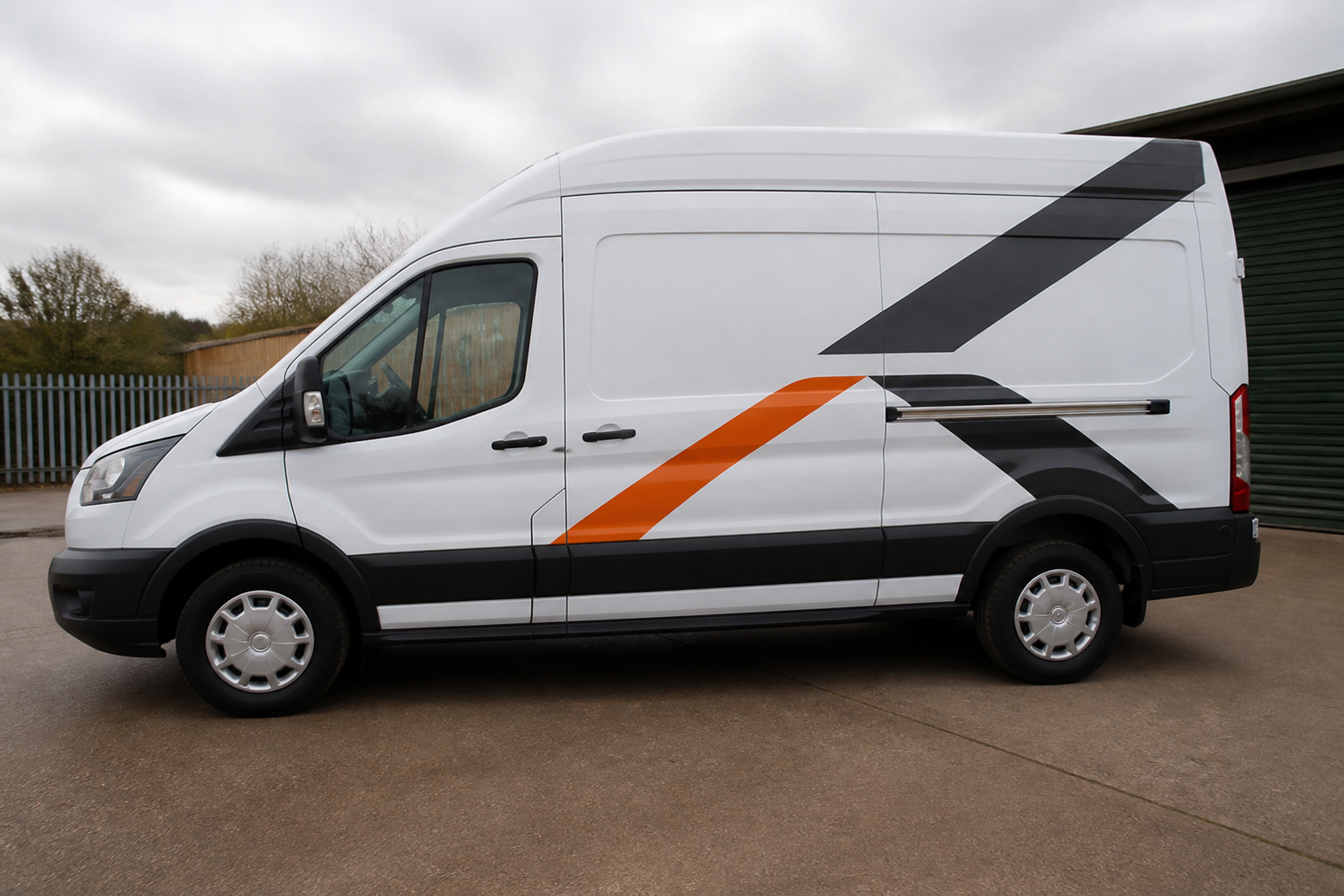 A white high-roof van with black and orange vinyl graphics on the side