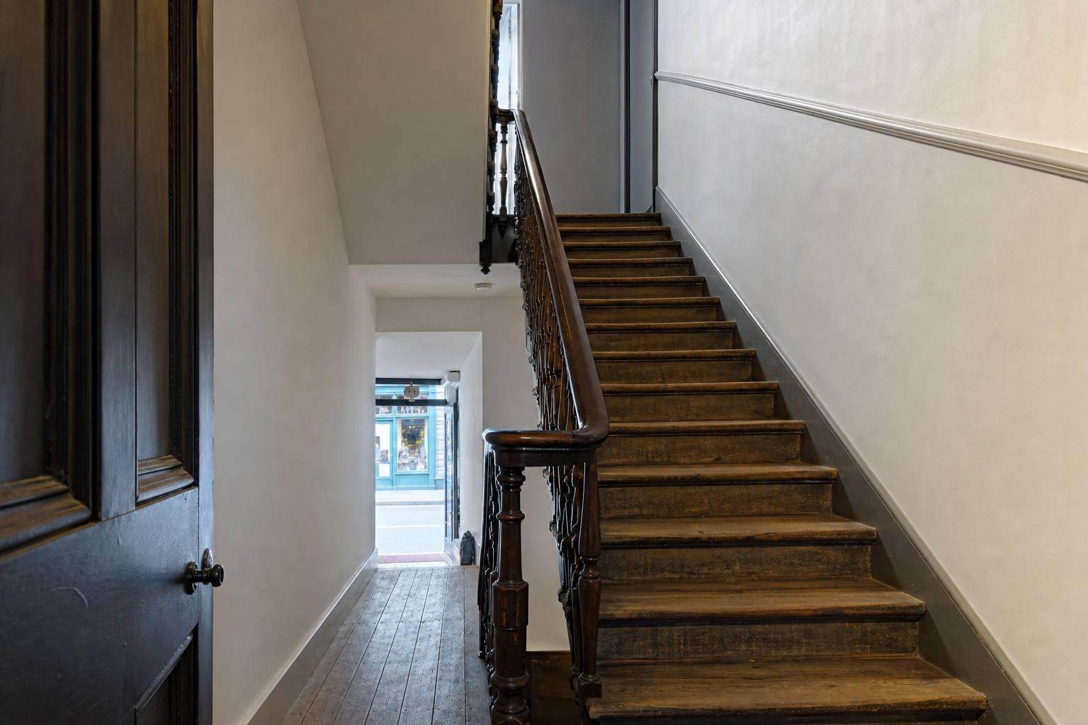 A shared wooden staircase to a first-floor practice, with no readable signs