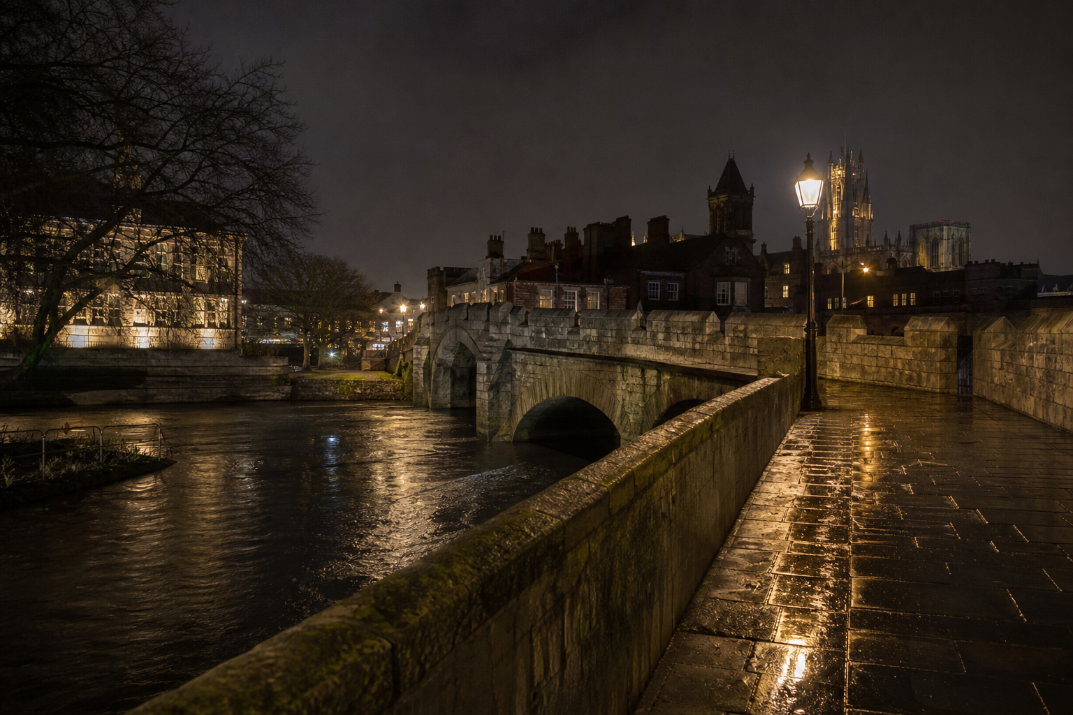 A historic stone bridge over a dark English river at night, with no readable signs